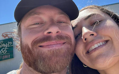 Selfie of two people smiling in front of a diner sign during Seattle city exploration game.