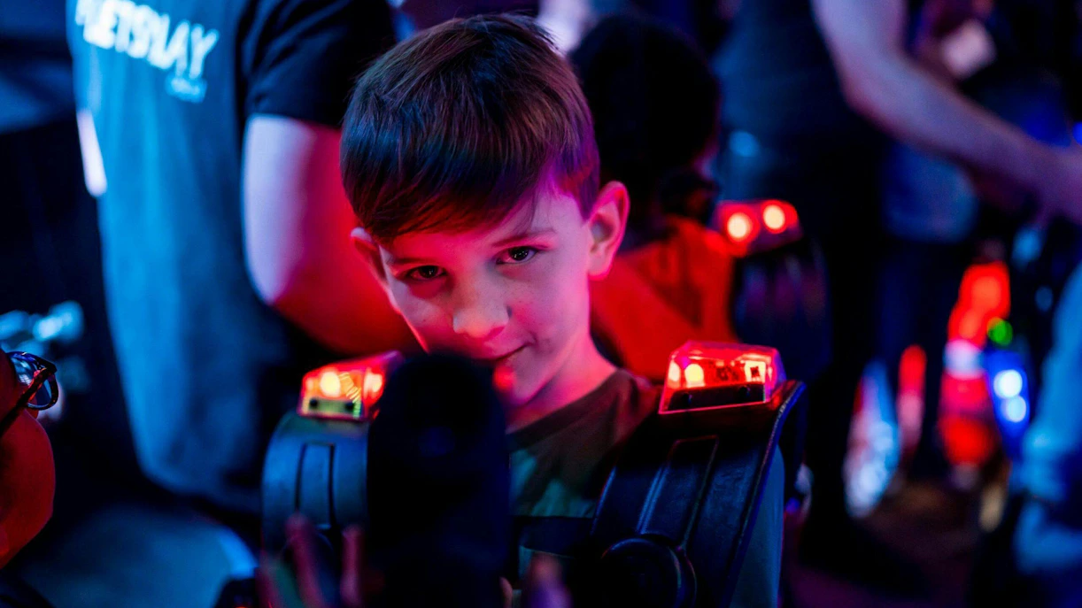 Child playing laser tag in Rotterdam with glowing gear.