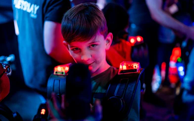 Child playing laser tag in Rotterdam with glowing gear.