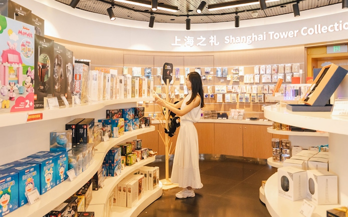 Woman browsing merchandise at Shanghai Tower Collection gift shop.