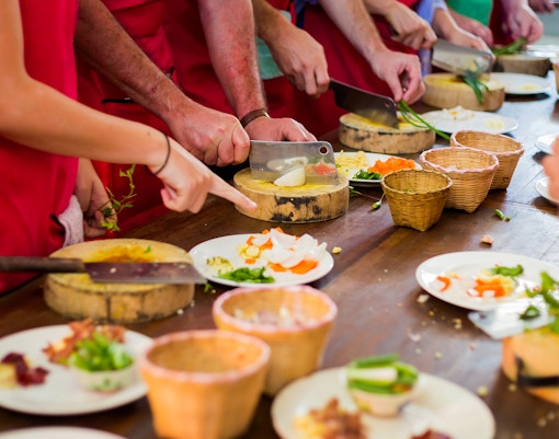 Group learning Thai cooking techniques in a Bangkok culinary class.