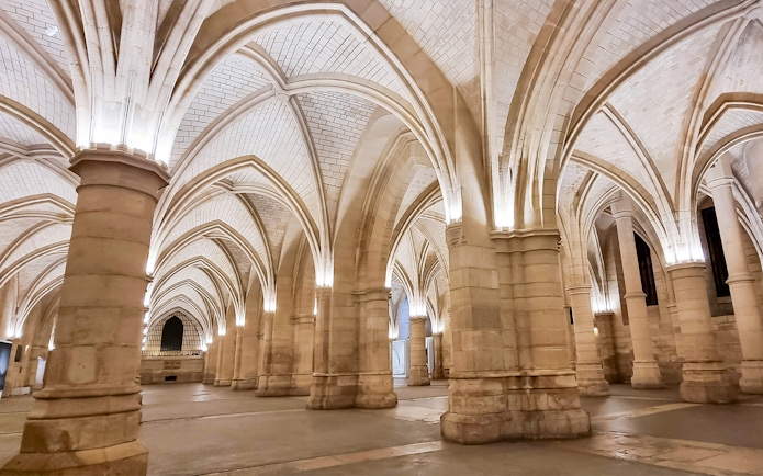 Conciergerie interior with vaulted ceilings and stone columns in Paris.