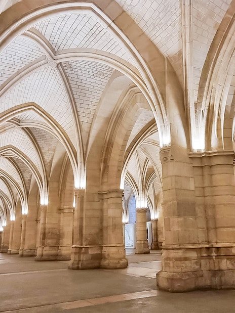 Conciergerie interior with vaulted ceilings and stone columns in Paris.