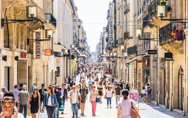 Crowded street in Bordeaux Old Town with shops and people exploring.