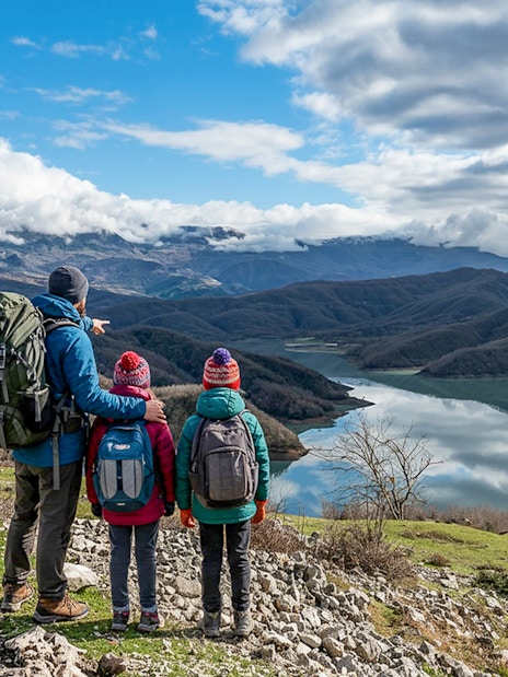 Family hiking near Bovilla Lake with mountain view in Albania.