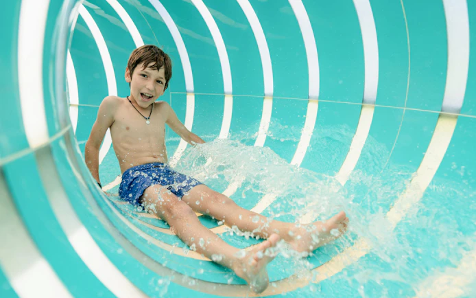 Child sliding in Jellyfish Twist water slide at Hurricane Harbor Arlington.
