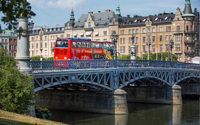 Red double-decker bus on a bridge in Stockholm during a Hop-On-Hop-Off tour.