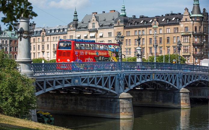 Red double-decker bus on a bridge in Stockholm during a Hop-On-Hop-Off tour.