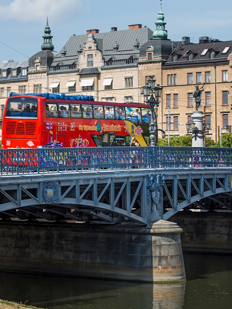 Red double-decker bus on a bridge in Stockholm during a Hop-On-Hop-Off tour.