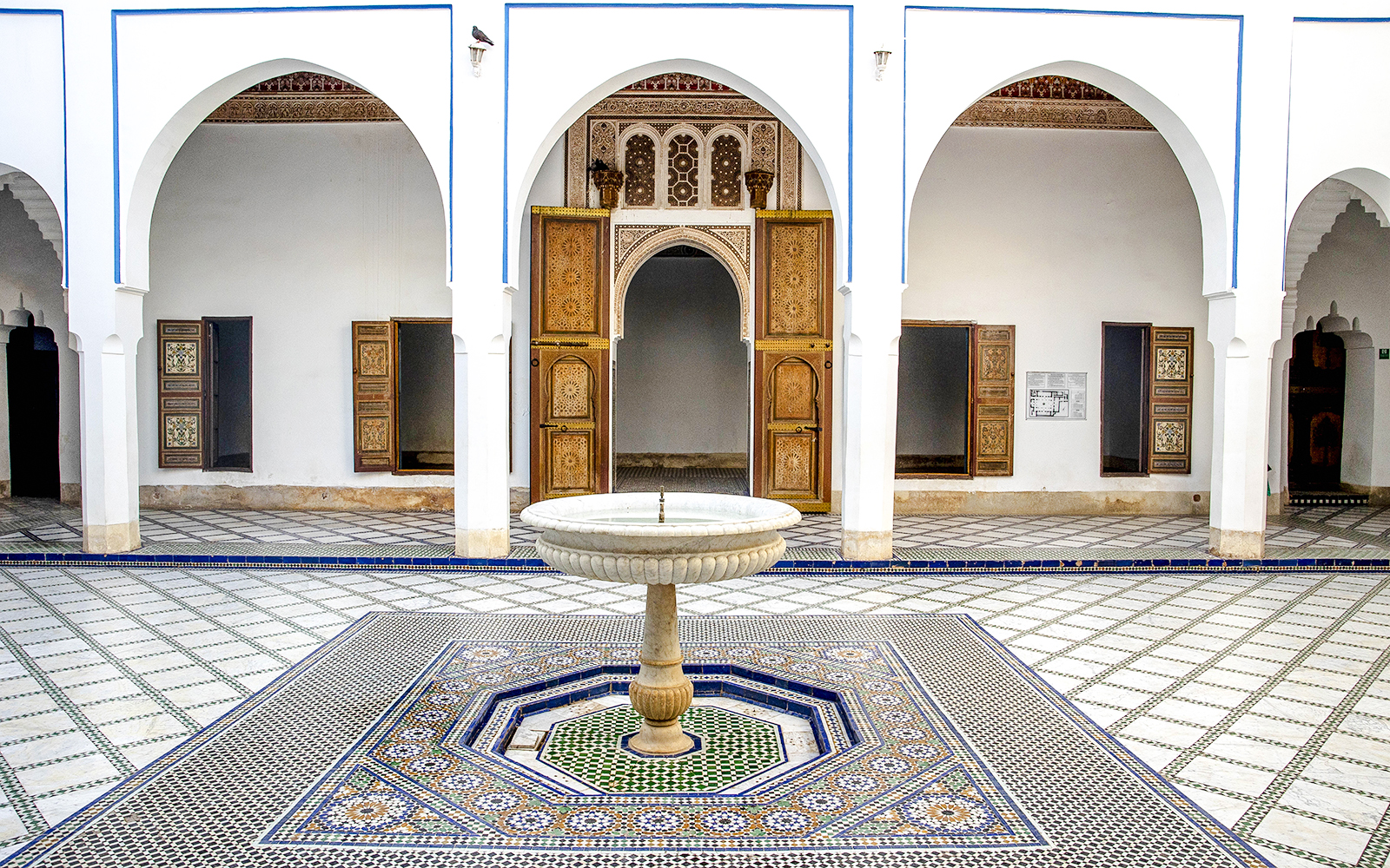 Bahia Palace courtyard with ornate fountain and arches in Marrakech, Morocco.