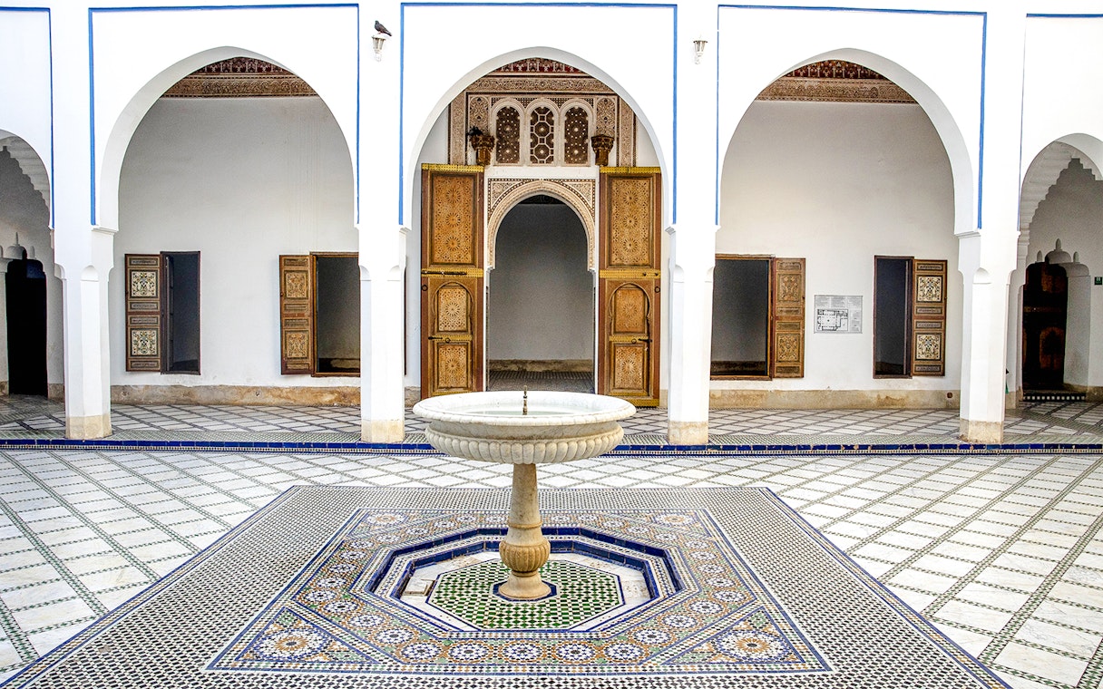 Bahia Palace courtyard with ornate fountain and arches in Marrakech, Morocco.