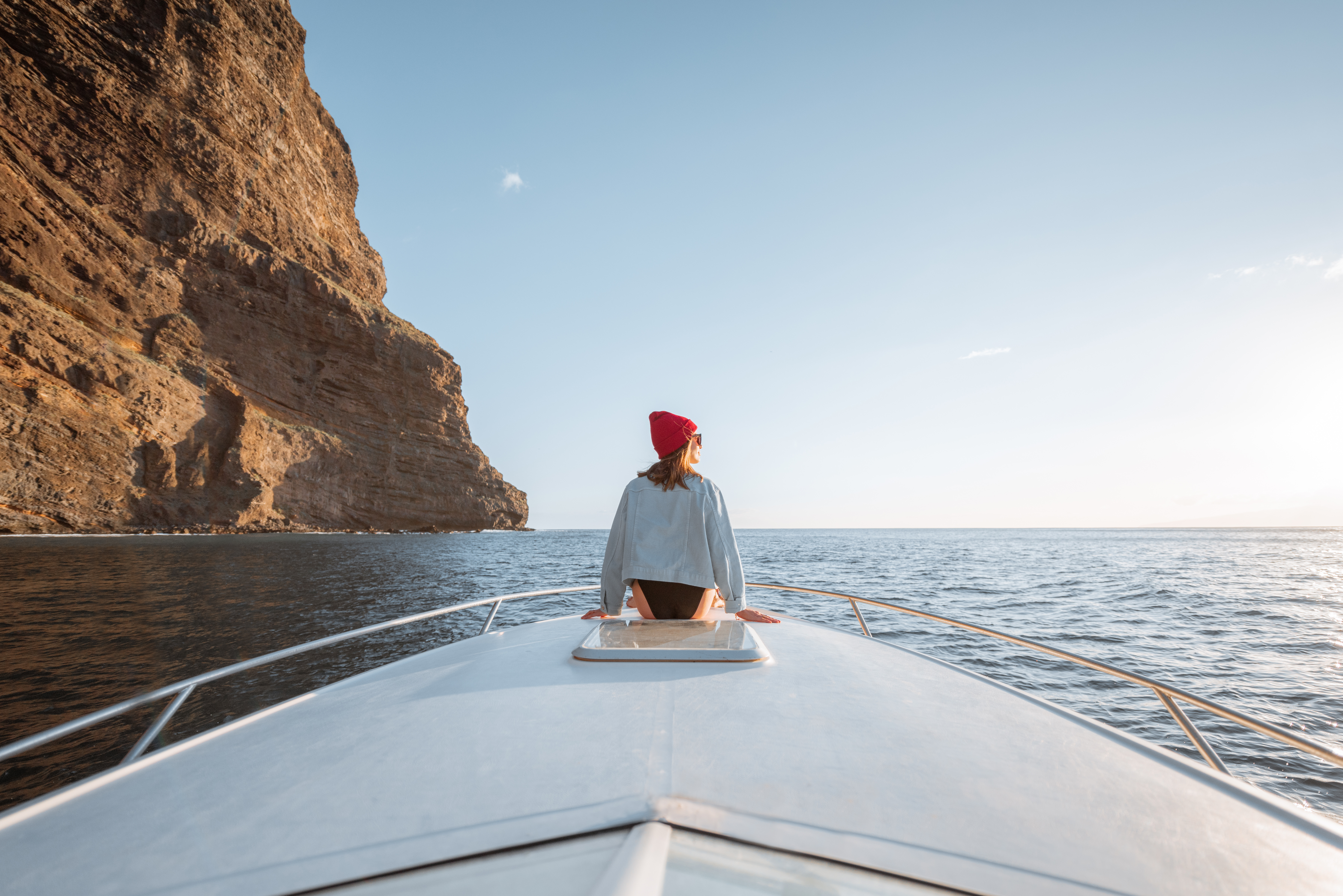 Person on boat near rocky cliff at Wahweap Marina, enjoying a scenic tour.