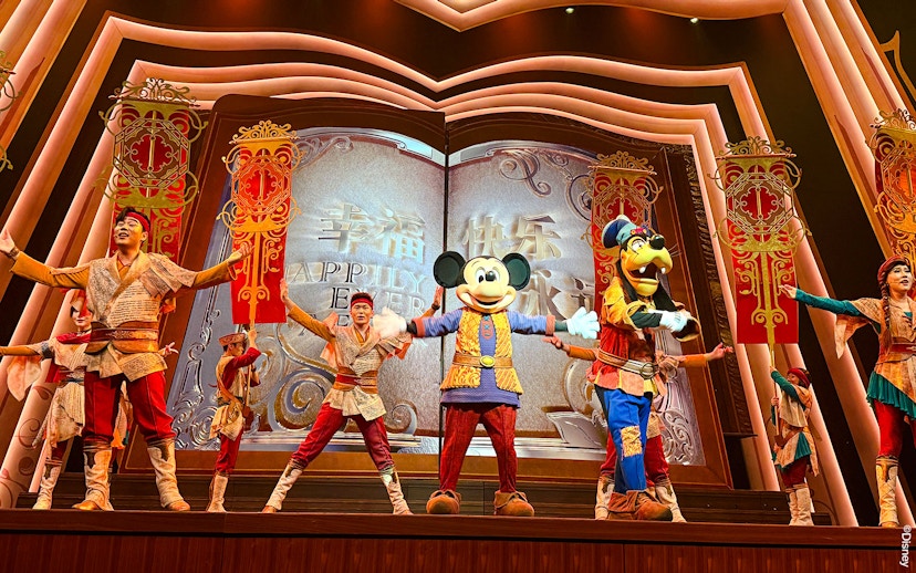 Mickey Mouse and performers on stage at Shanghai Disney show.
