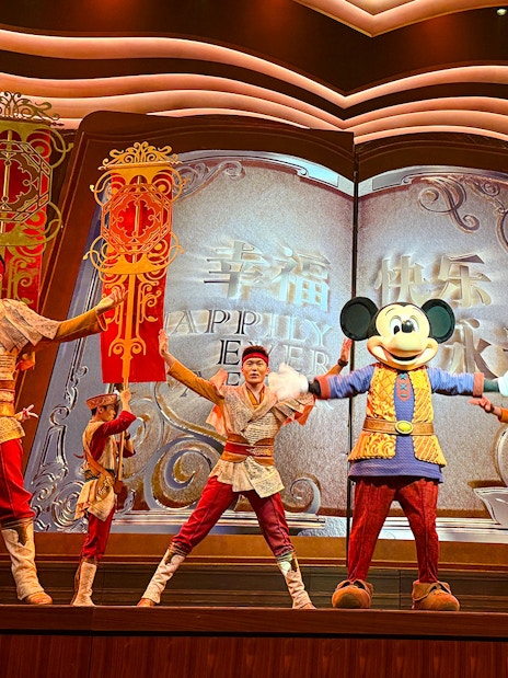 Mickey Mouse and performers on stage at Shanghai Disney show.