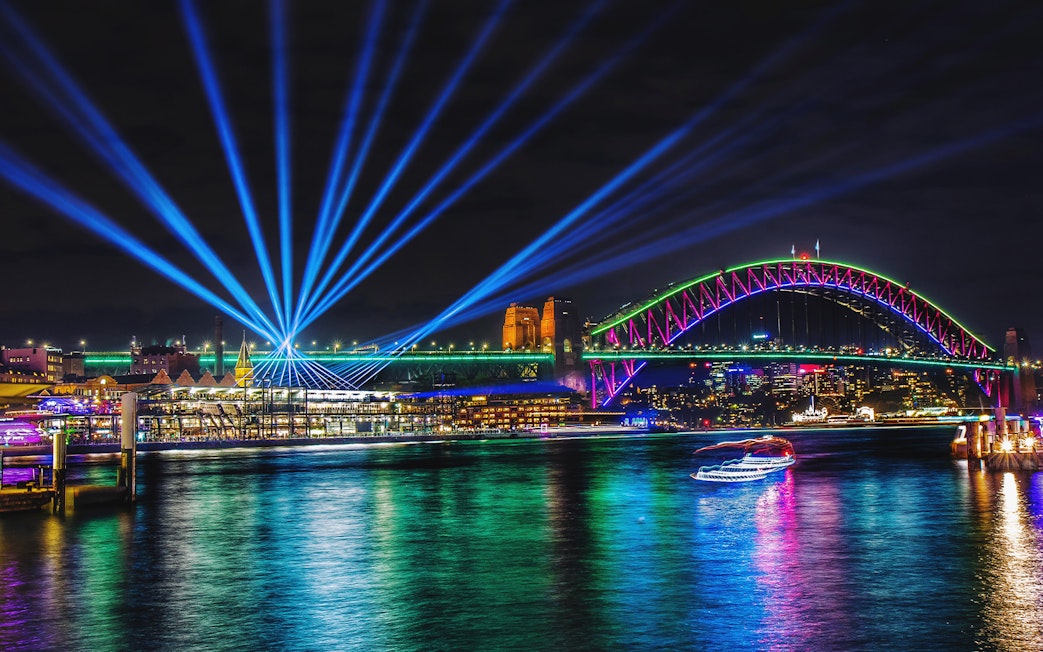 Sydney Harbour Bridge illuminated during Vivid Sydney, viewed from a tall ship dinner cruise.