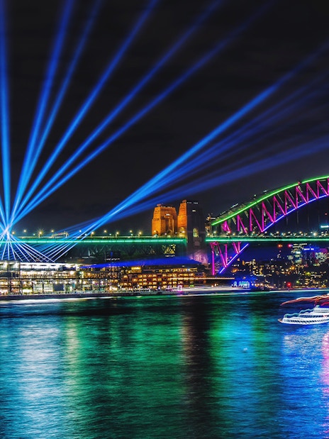 Sydney Harbour Bridge illuminated during Vivid Sydney, viewed from a tall ship dinner cruise.