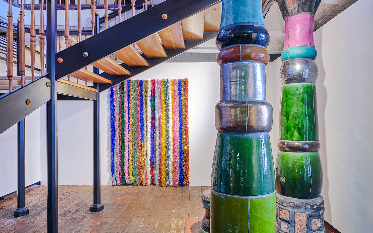 KUNST HAUS WIEN Antimatter Factory exhibit with colorful vertical art and unique architectural columns.