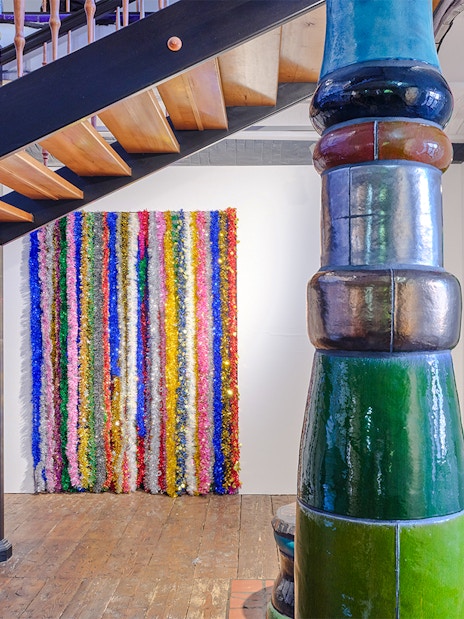 KUNST HAUS WIEN Antimatter Factory exhibit with colorful vertical art and unique architectural columns.