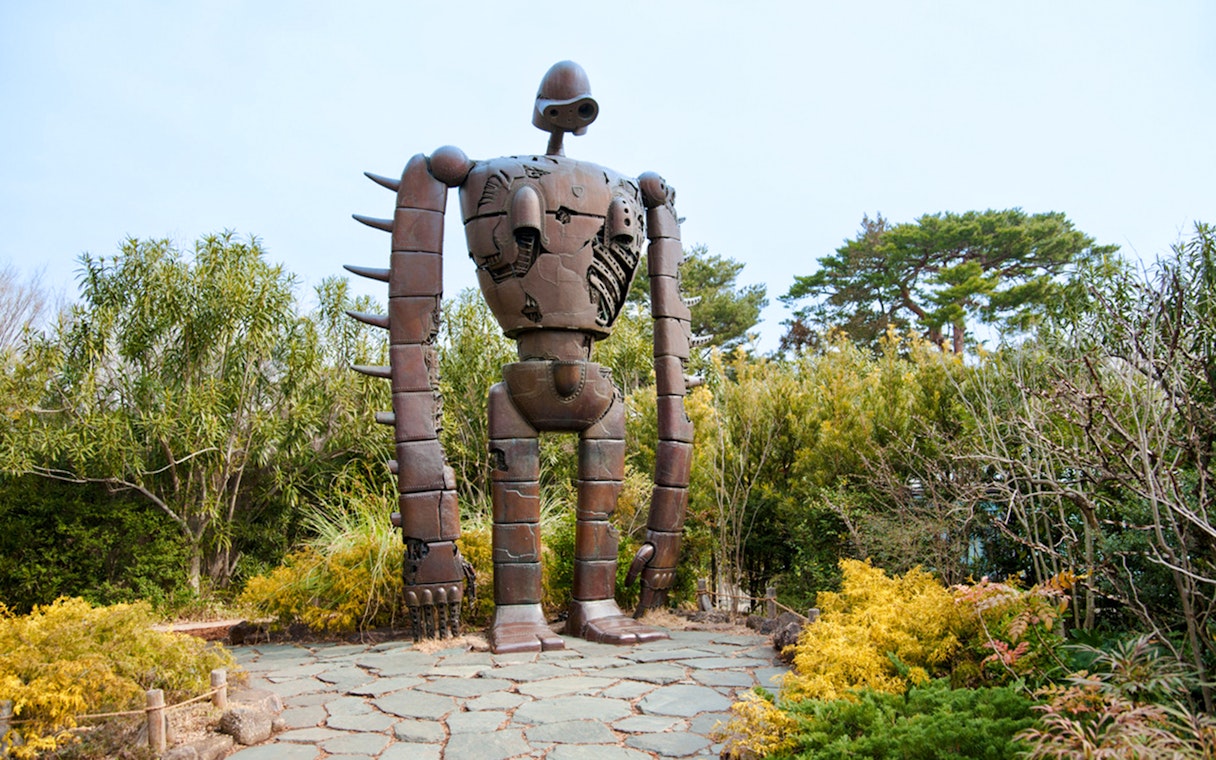 Giant robot statue surrounded by greenery at Ghibli Museum.