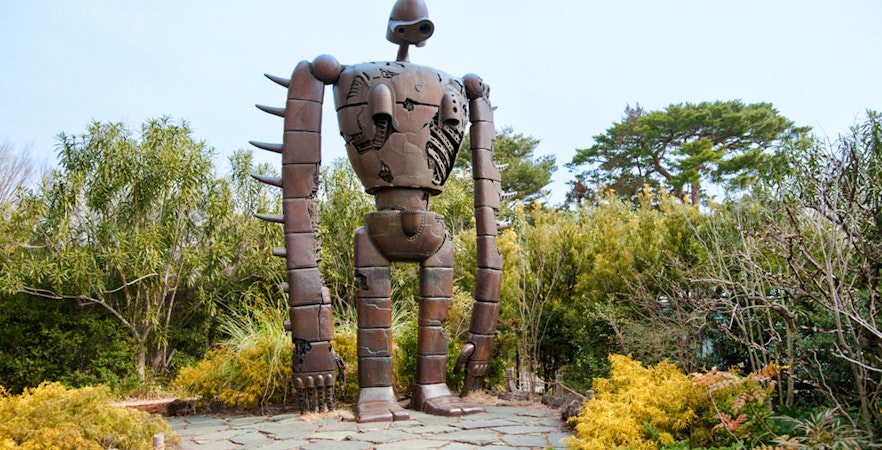 Giant robot statue surrounded by greenery at Ghibli Museum.