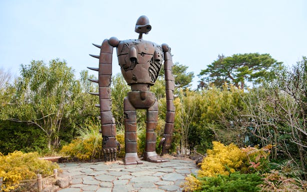 Giant robot statue surrounded by greenery at Ghibli Museum.