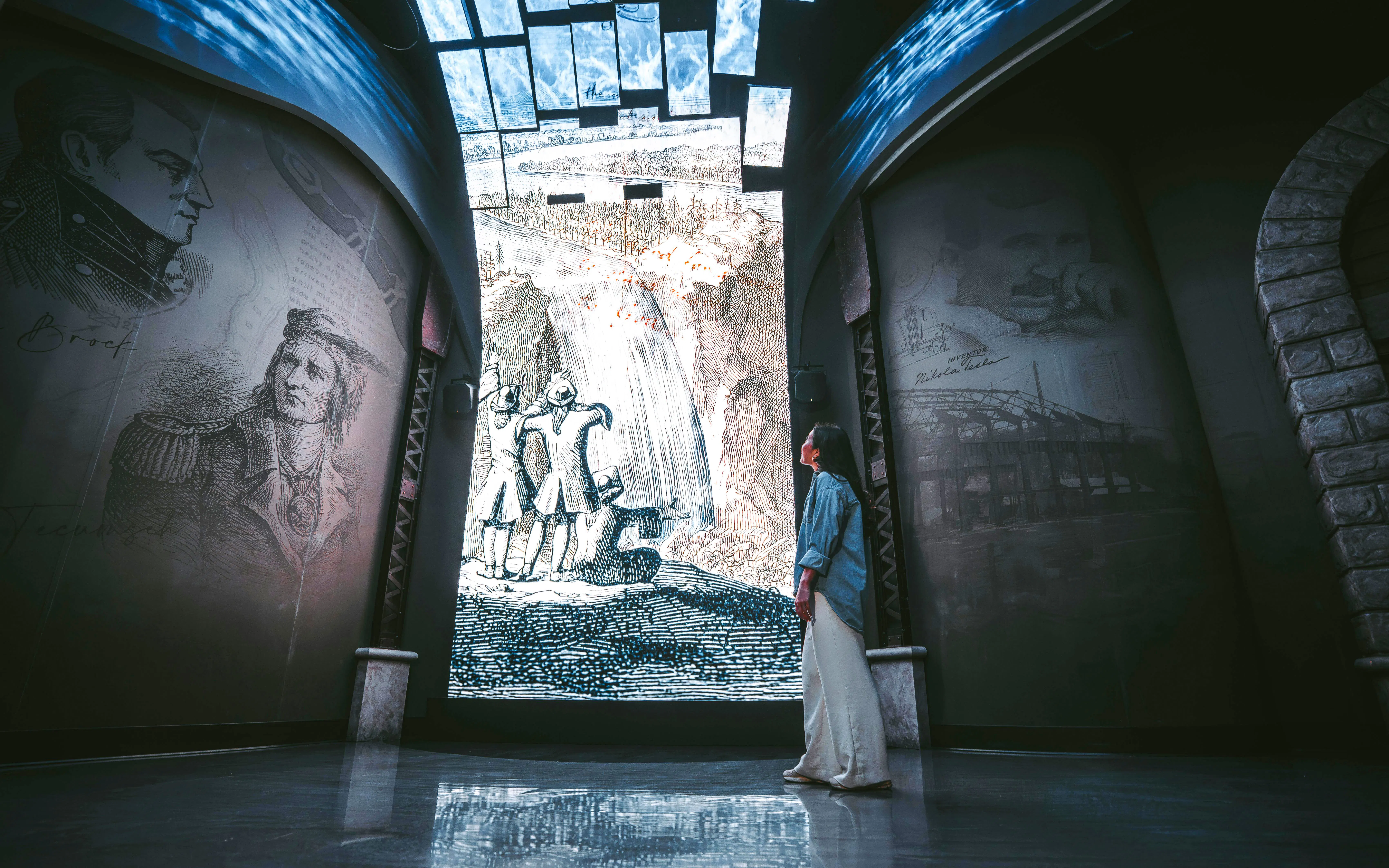 Visitor admiring historical Niagara Falls mural at Niagara Takes Flight, Canada.