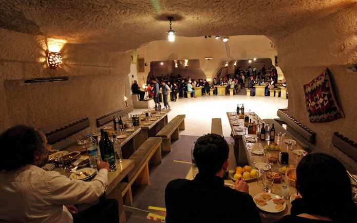 Turkish Night Show in a carved cave restaurant, Cappadocia, with guests dining.