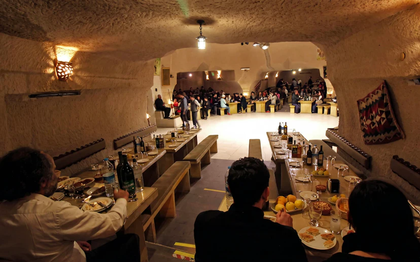 Turkish Night Show in a carved cave restaurant, Cappadocia, with guests dining.