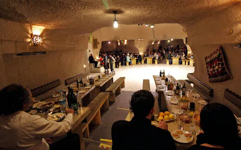Turkish Night Show in a carved cave restaurant, Cappadocia, with guests dining.