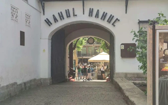 Entrance to Hanul Manuc courtyard, Bucharest, with visitors exploring the historic site.