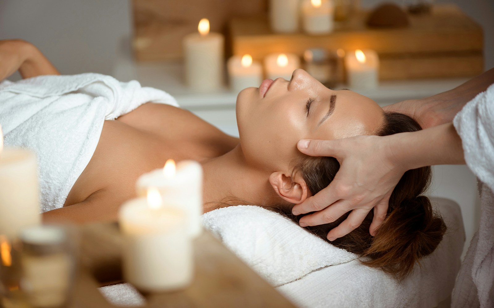 A woman getting a face massage at the spa