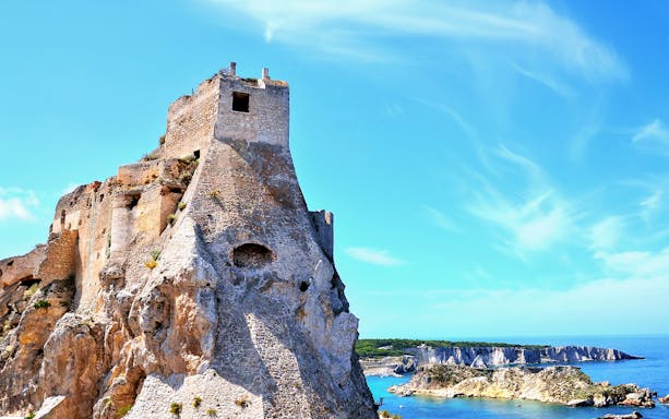 Ancient stone fortress on Tremiti Islands with coastal cliffs and blue sea.