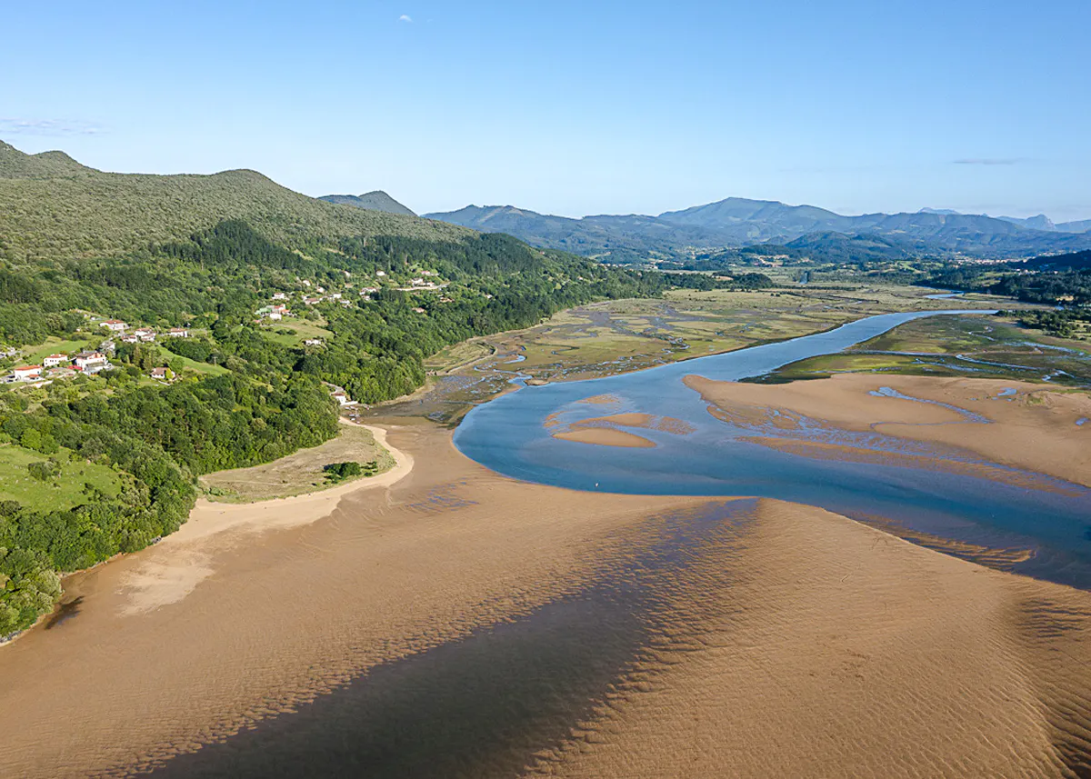 Aerial view of Mundaka estuary with lush greenery and winding river near Bilbao.