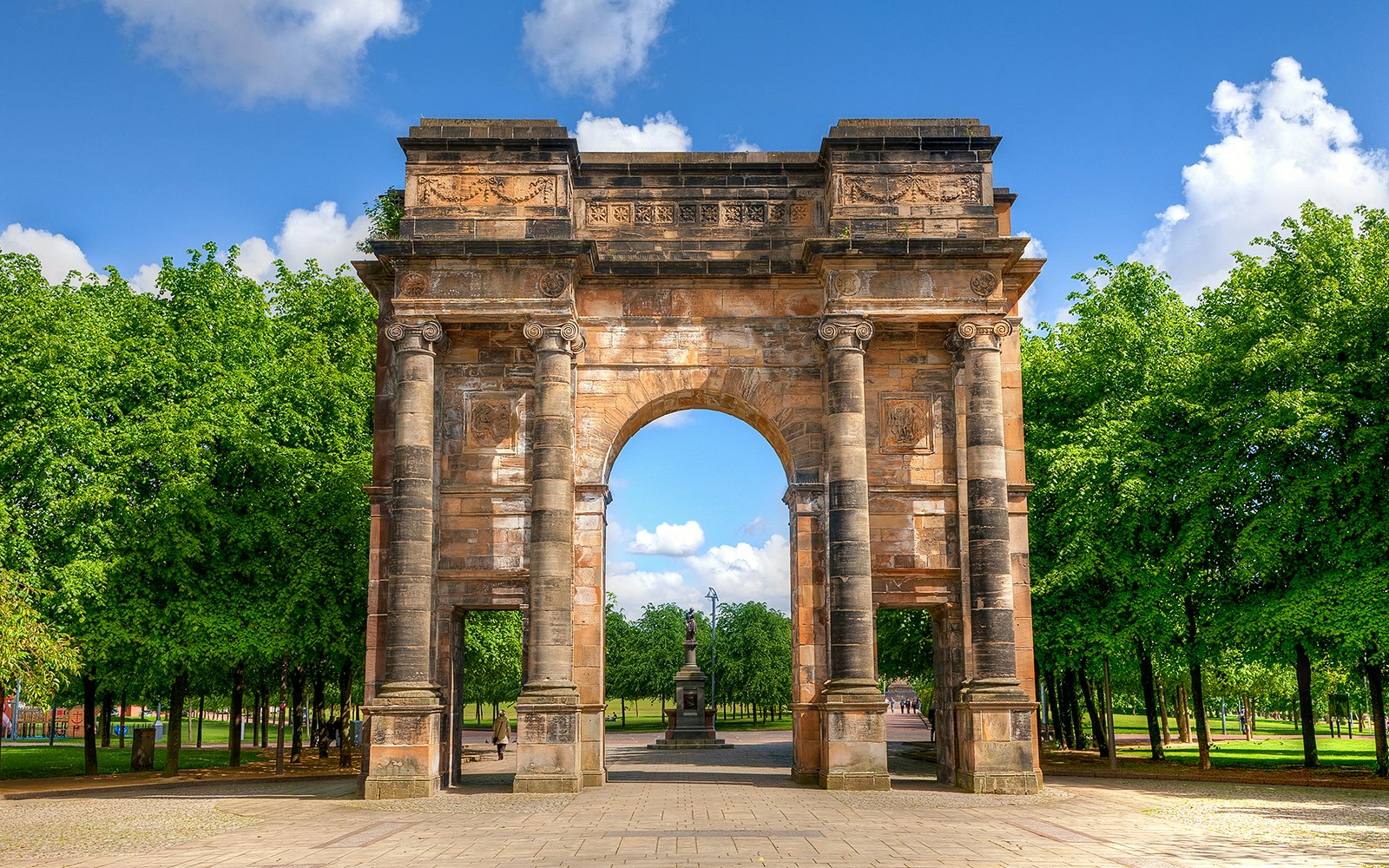 McLennan Arch in Glasgow Green, Scotland, historic stone archway surrounded by lush park greenery