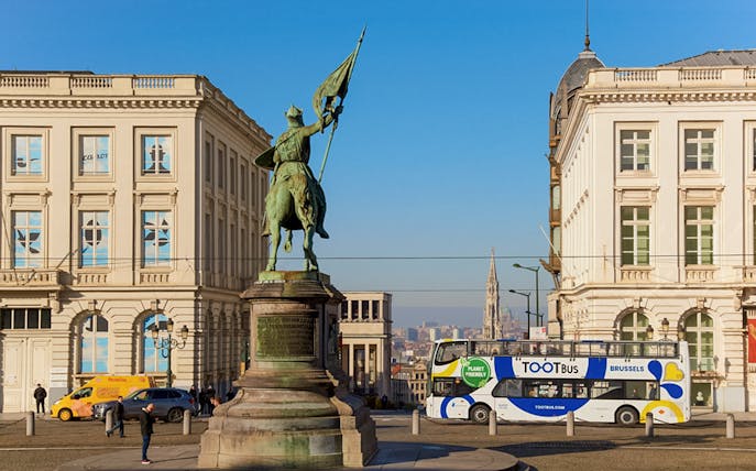 Statue of Godfrey of Bouillon with hop-on hop-off bus in Brussels city center.