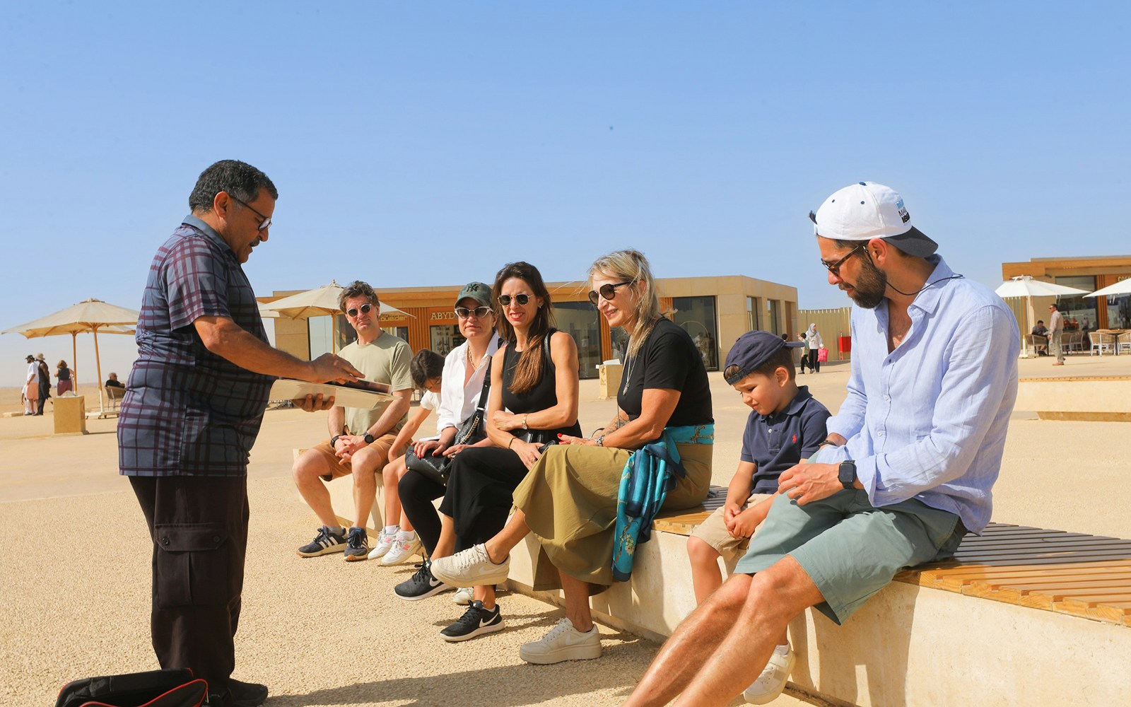 Tourists listening to a guide at Giza Pyramids and the Sphinx, Egypt.