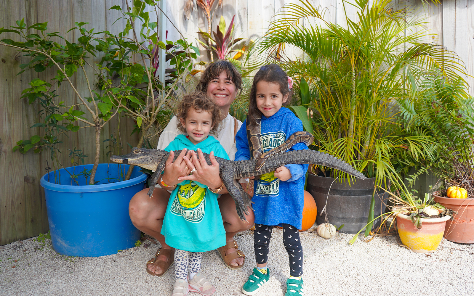 Family holding a small alligator at Holiday Park animal encounter.
