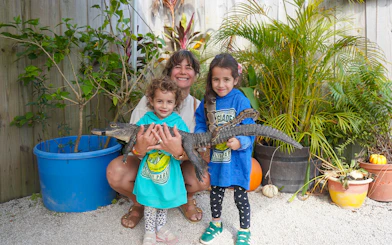 Family holding a small alligator at Holiday Park animal encounter.