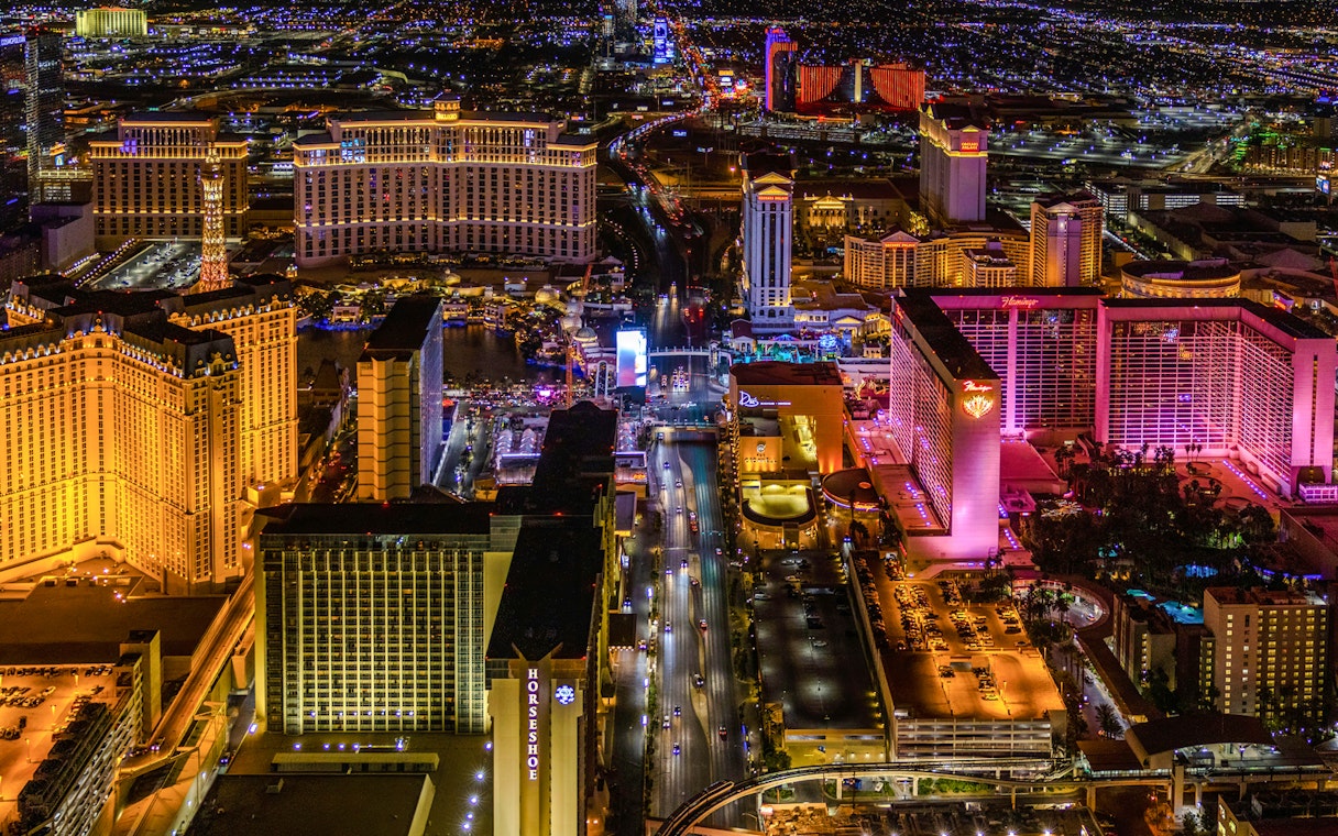 Aerial view of the Las Vegas Strip at night with illuminated hotels and casinos.