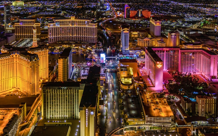Aerial view of the Las Vegas Strip at night with illuminated hotels and casinos.