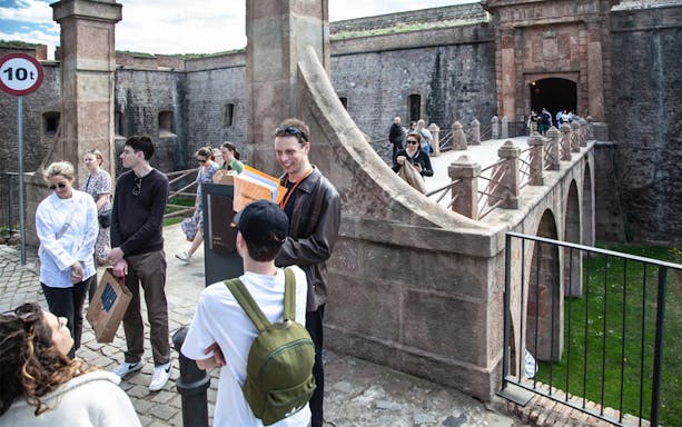 Tour group exploring Montjuïc Castle entrance on a guided walking tour.