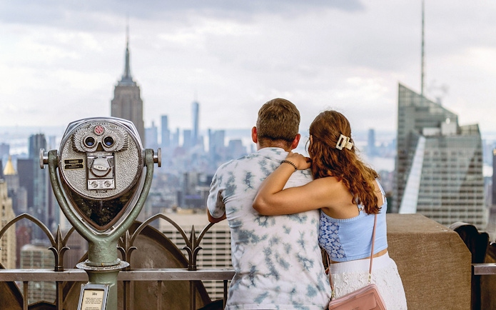 Couple enjoying New York City skyline from Top of the Rock Observation Deck.