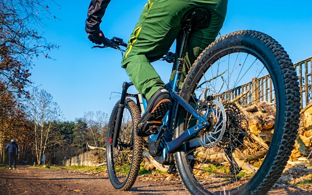 Cyclist on electric bike during guided tour in Nice forest path.
