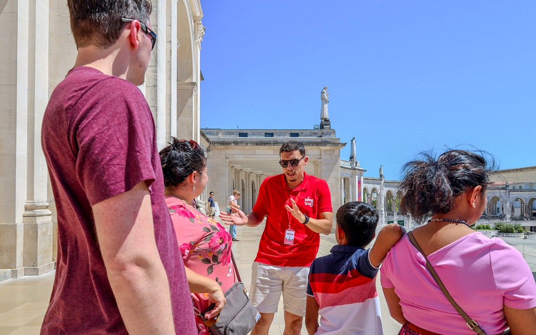 Tour guide explaining the history of Fátima to visitors during a full-day tour from Porto.