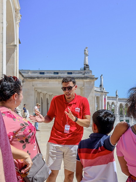 Tour guide explaining the history of Fátima to visitors during a full-day tour from Porto.