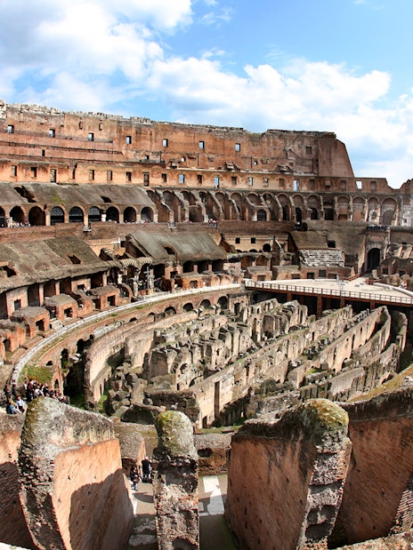 Colosseum interior view with ancient stone arches and arena floor in Rome, Italy.