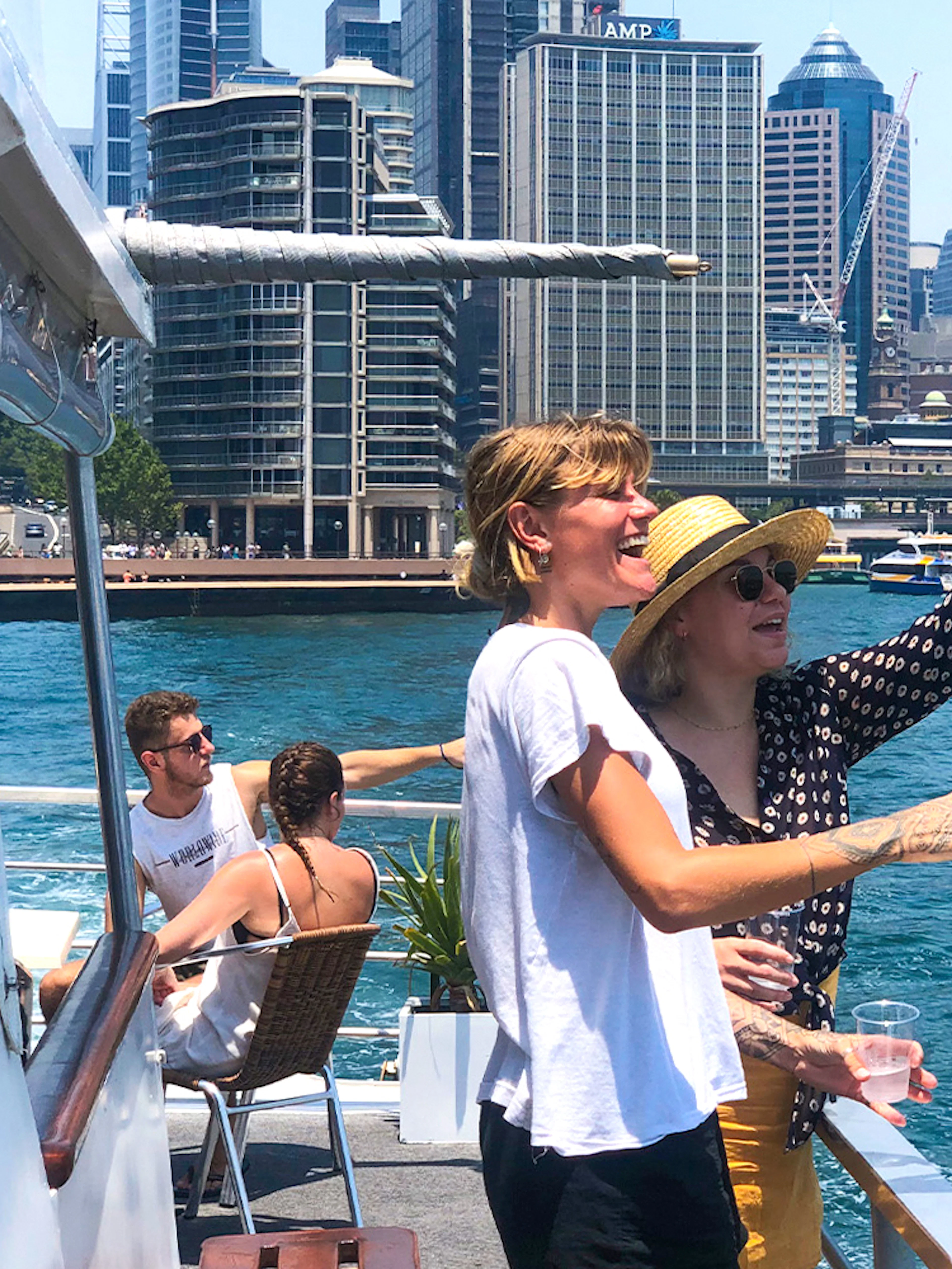 Tourists enjoying a Sydney Harbour sightseeing cruise with city skyline views.