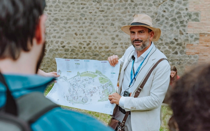 Tour guide in Pompeii holding a map and briefing tourists.
