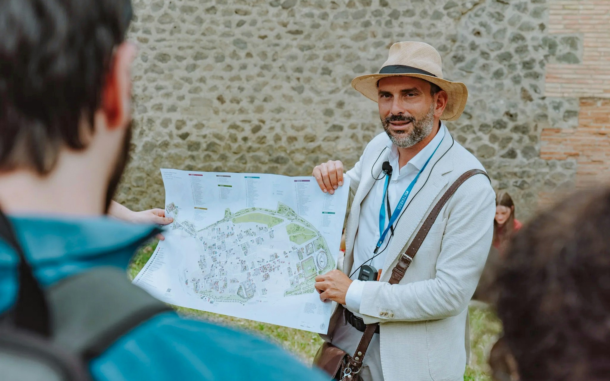 Tour guide in Pompeii holding a map and briefing tourists.