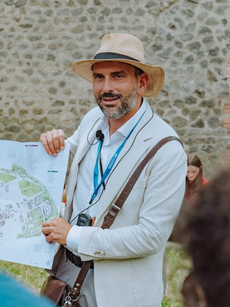 Tour guide in Pompeii holding a map and briefing tourists.